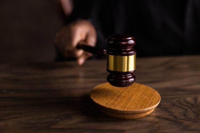 A judge holding his gavel inside the courtroom